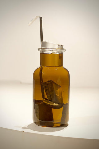 Image:  The sculpture presents a jar with a prominent spoon inside, accompanied by diminutive houses.