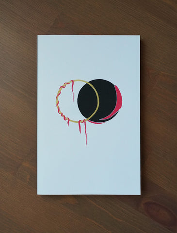 An ivory coloured notebook with a design on the cover. Ven Diagram in black, red and gold with vines hanging from it. 